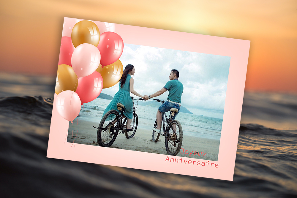 Une carte romantique pour un anniversaire avec un couple faisant du vélo sur la plage